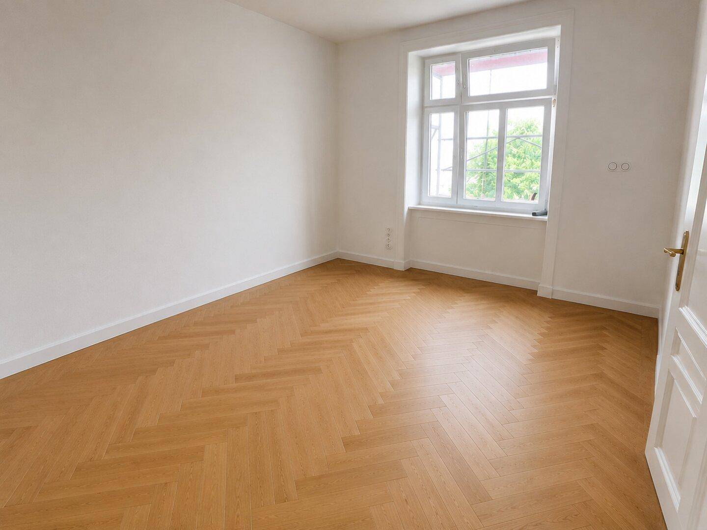 Geräumiges, helles Zimmer mit Fischgrätparkett und großem Fenster, frisch renoviert.