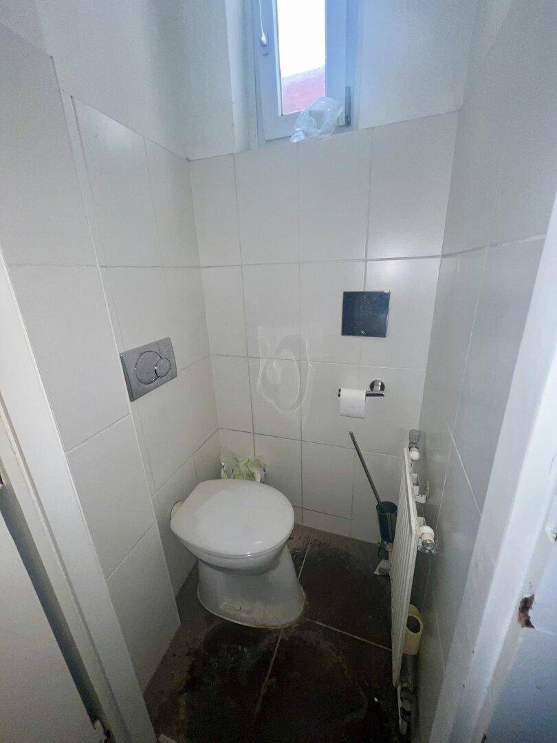 Kleines WC mit Wand-WC und Heizkörper, einfach und funktional.