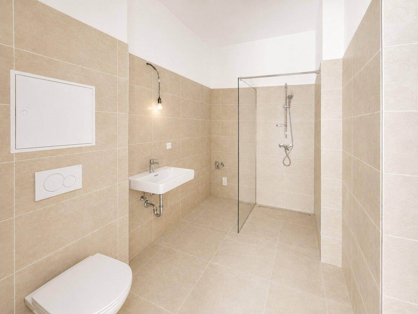 Modernes Badezimmer mit beigefarbenen Fliesen, WC, Waschbecken und einer begehbaren Dusche.