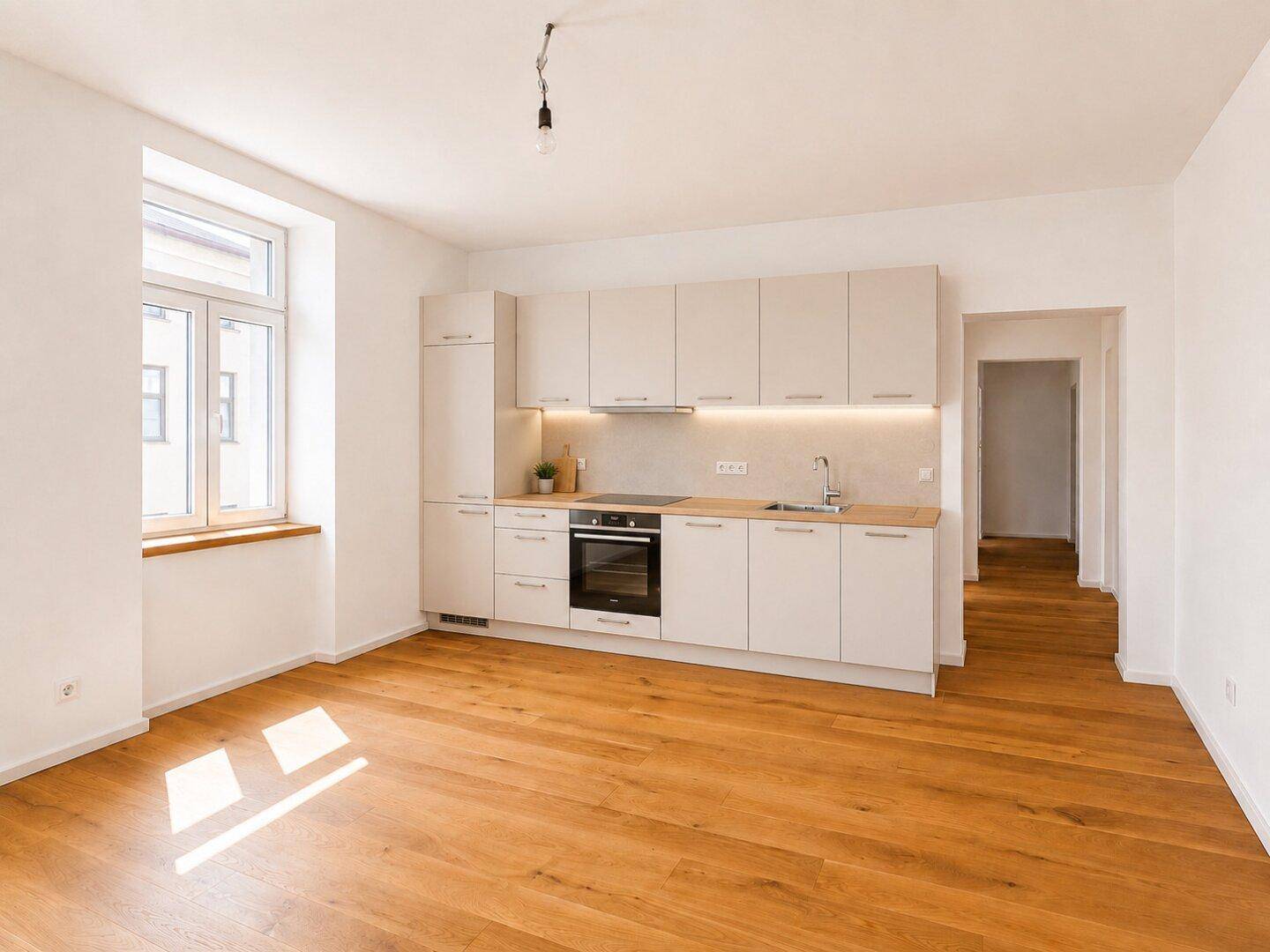 Moderne Einbauküche in hellem Design mit Holz-Arbeitsplatte und Parkettboden.