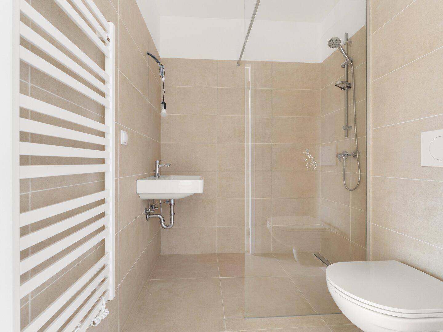 Modernes Badezimmer mit ebenerdiger Dusche, Wand-WC und beheiztem Handtuchhalter.