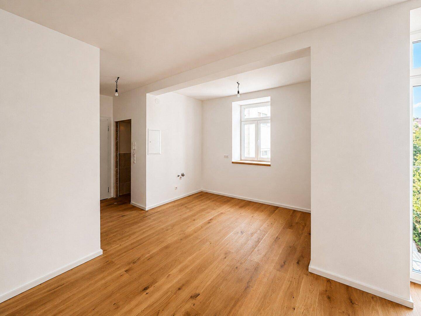 Geräumiges, helles Zimmer mit Holzboden und einem Fenster, bereit zur individuellen Gestaltung.