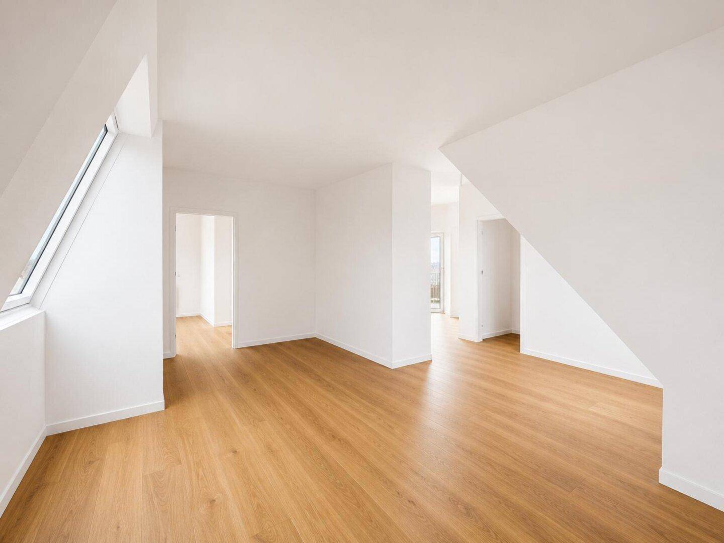 Geräumiger, unmöblierter Raum mit Holzboden und Dachschrägen, bereit zur individuellen Gestaltung.