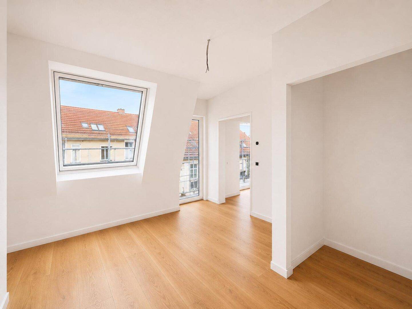 Unmöblierter Raum mit Holzboden und Dachfenstern, bietet viel natürliches Licht und Ausblick.