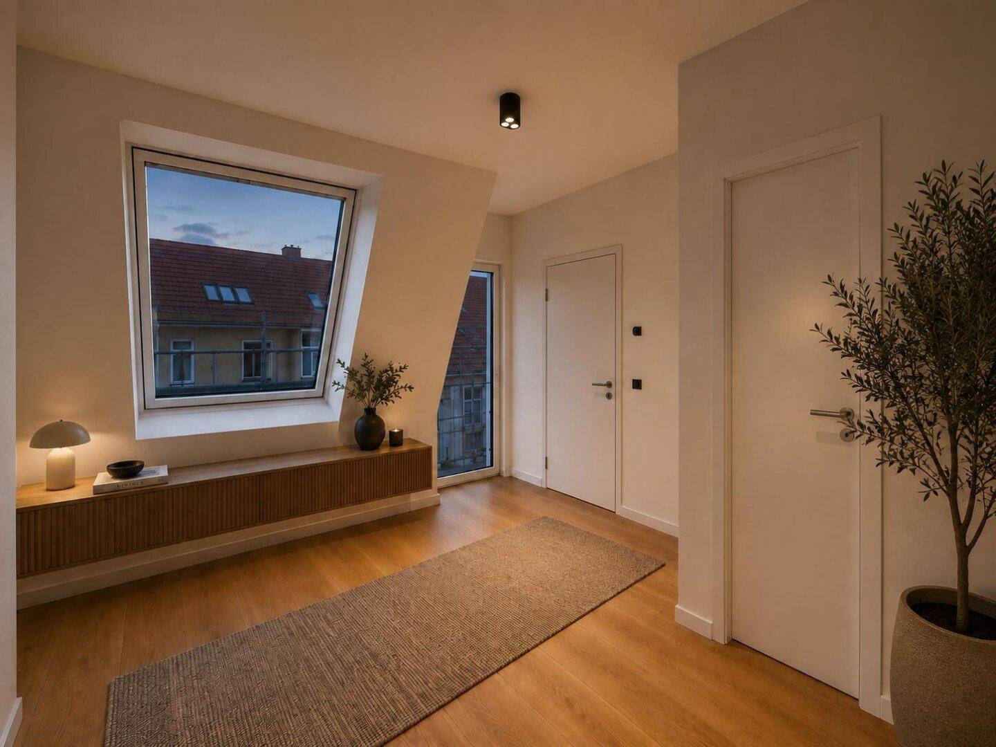 Heller Flur mit Holzboden, Dachschrägen und einem großen Dachfenster, einladend und funktional.