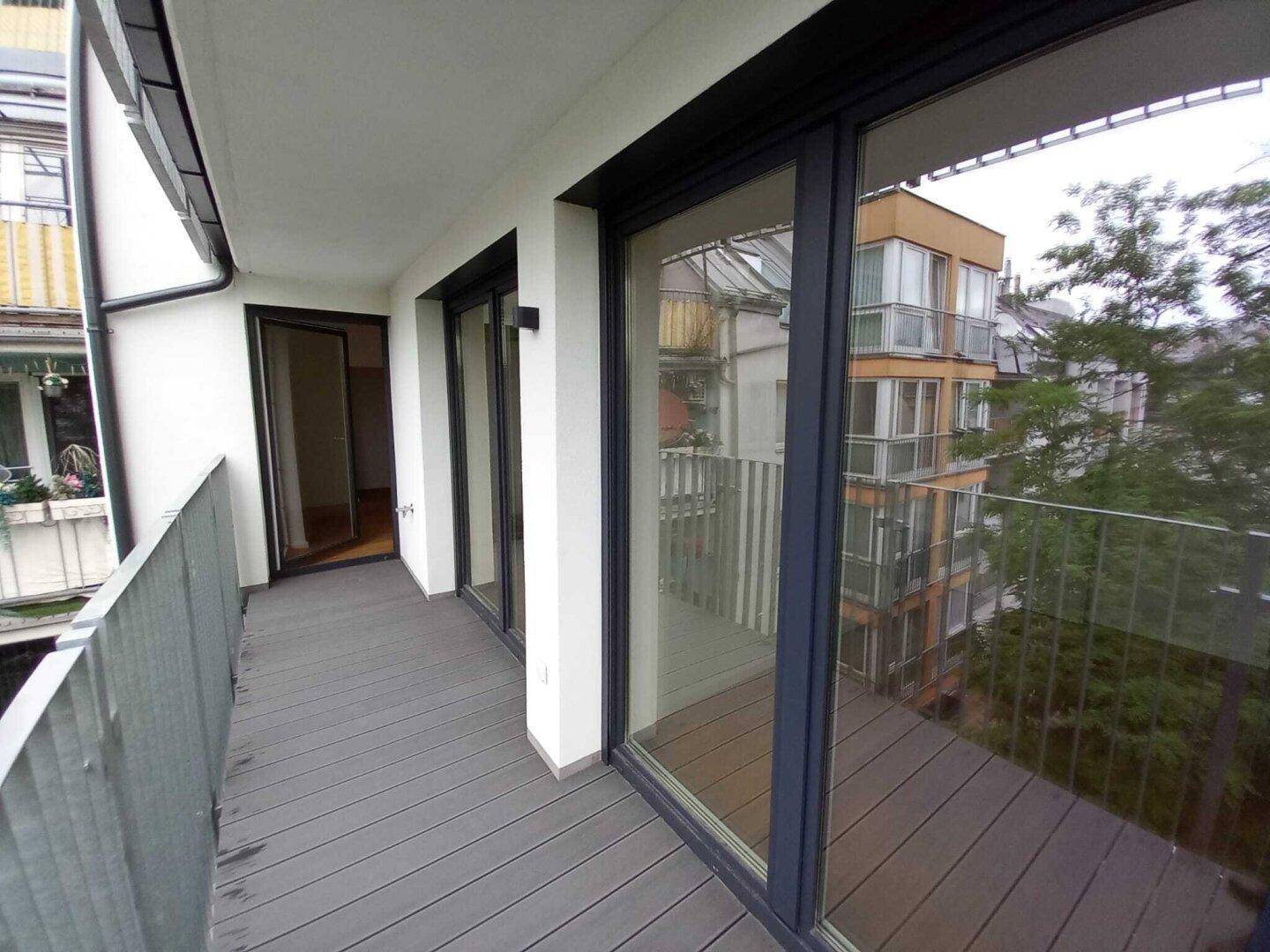 Geräumiger Balkon mit Blick auf die Nachbargebäude und viel Grün, ideal zum Entspannen.