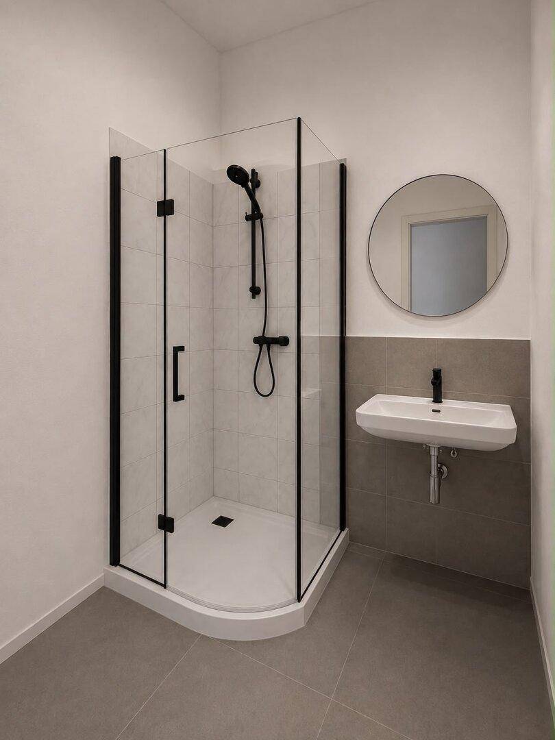 Modernes Badezimmer mit Duschkabine, Waschbecken und rundem Spiegel in neutralen Farben.
