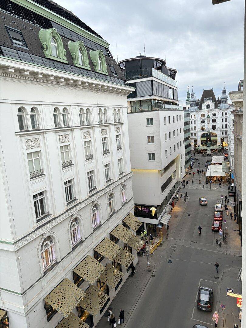 Belebtes Stadtbild mit historischen Gebäuden, Geschäften und Passanten auf der Straße.