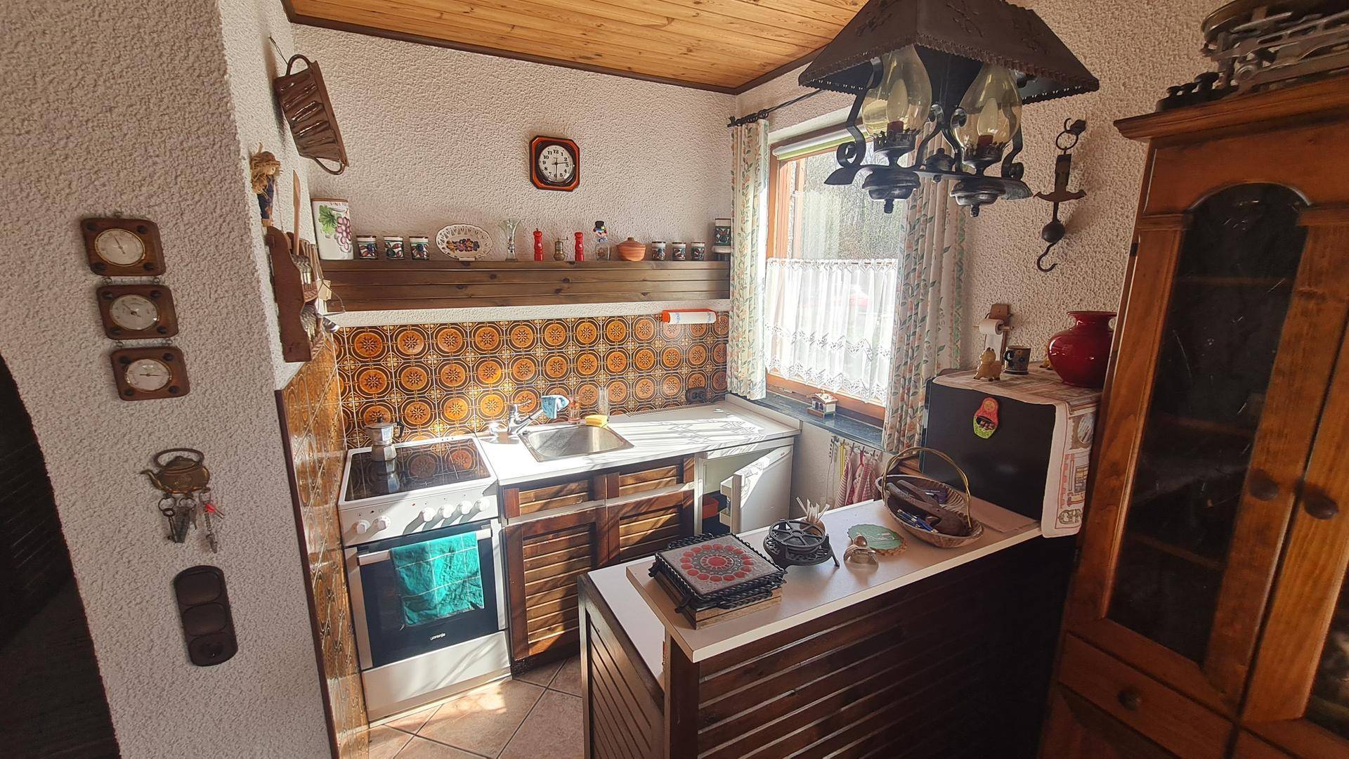Funktionale Küche im traditionellen Stil mit gemusterten Fliesen und Holzschränken.