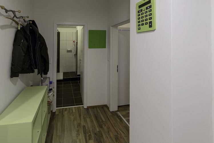 Heller Flur mit Garderobe und Laminatboden, der zu weiteren Räumen der Wohnung führt.