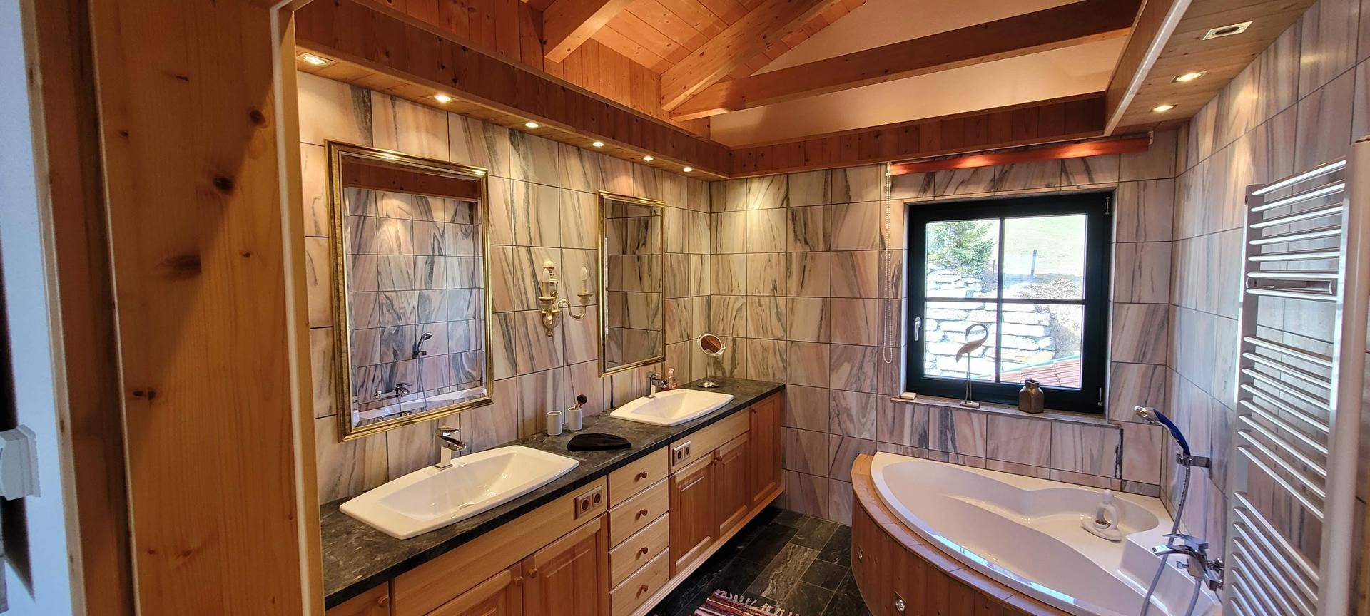 Elegantes Badezimmer mit Doppelwaschbecken, Badewanne und Fenster.