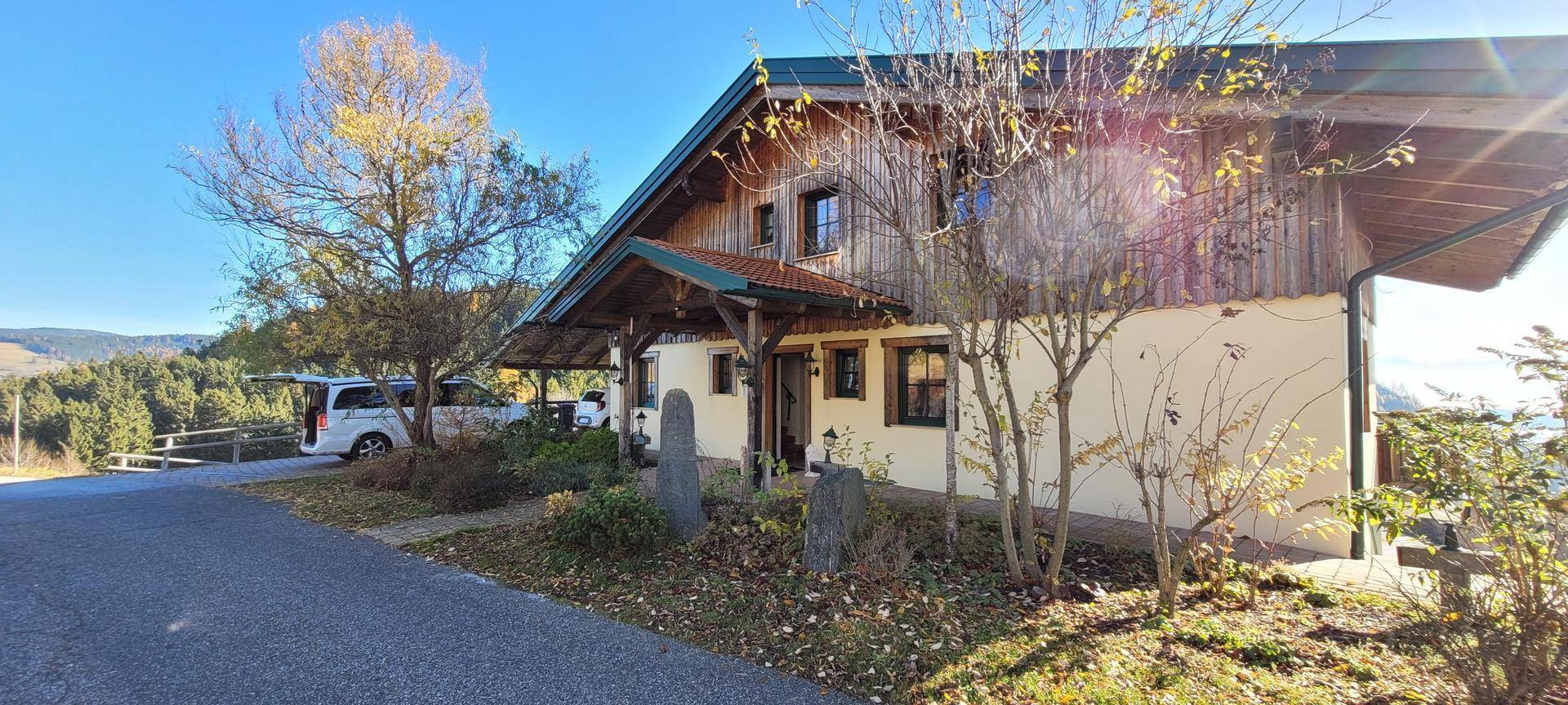Charmantes Holzhaus mit traditioneller Architektur und sonnigem Vorplatz.