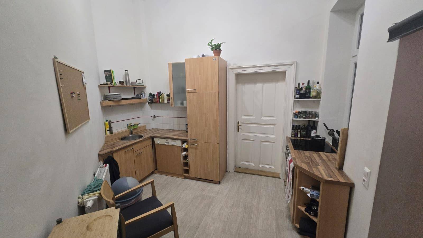 Kleine Küche mit Holzschränken, Arbeitsplatte und einfacher Ausstattung.