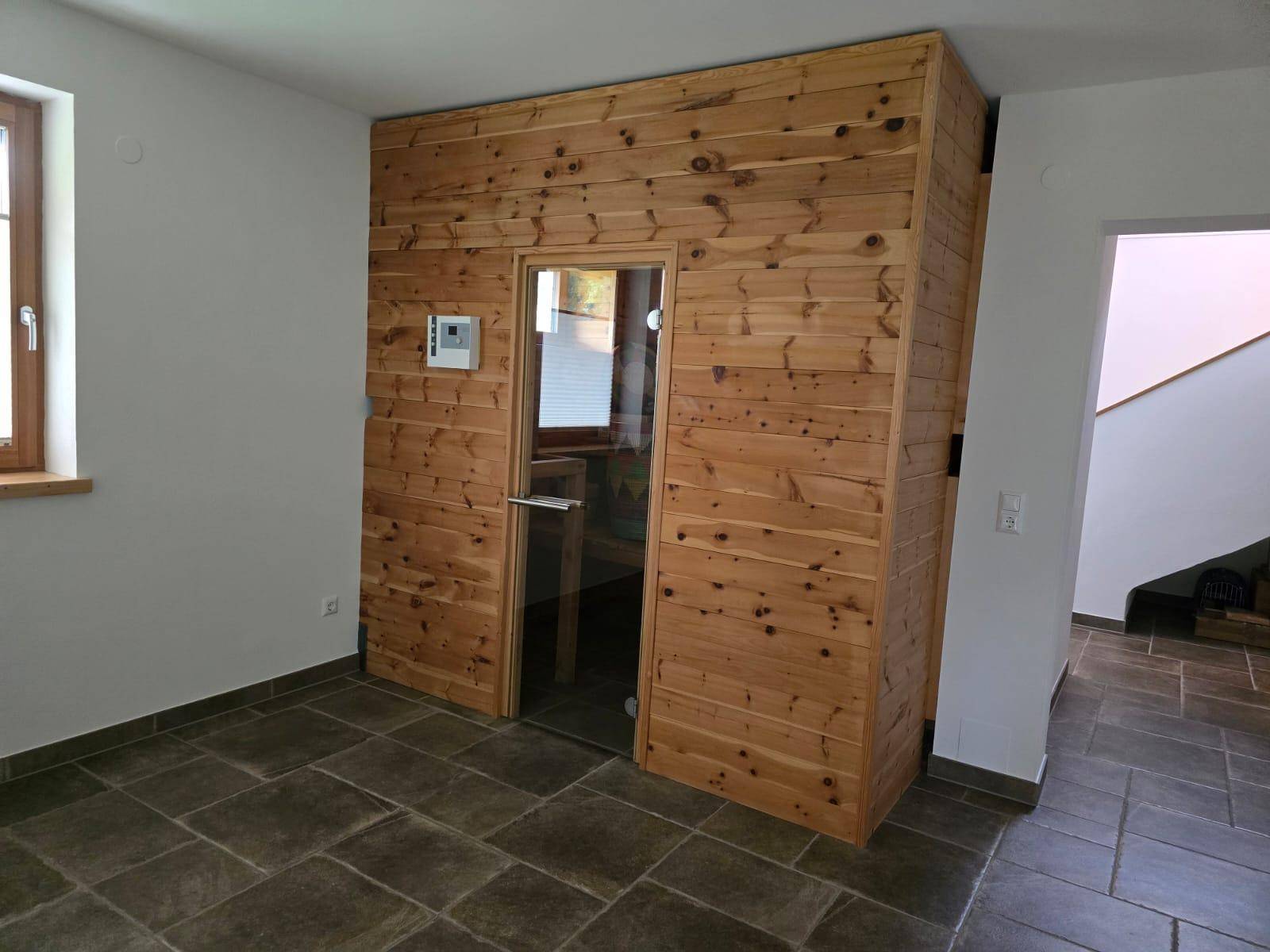 Private Sauna mit Holzverkleidung und Glasfront, ideal zur Entspannung.