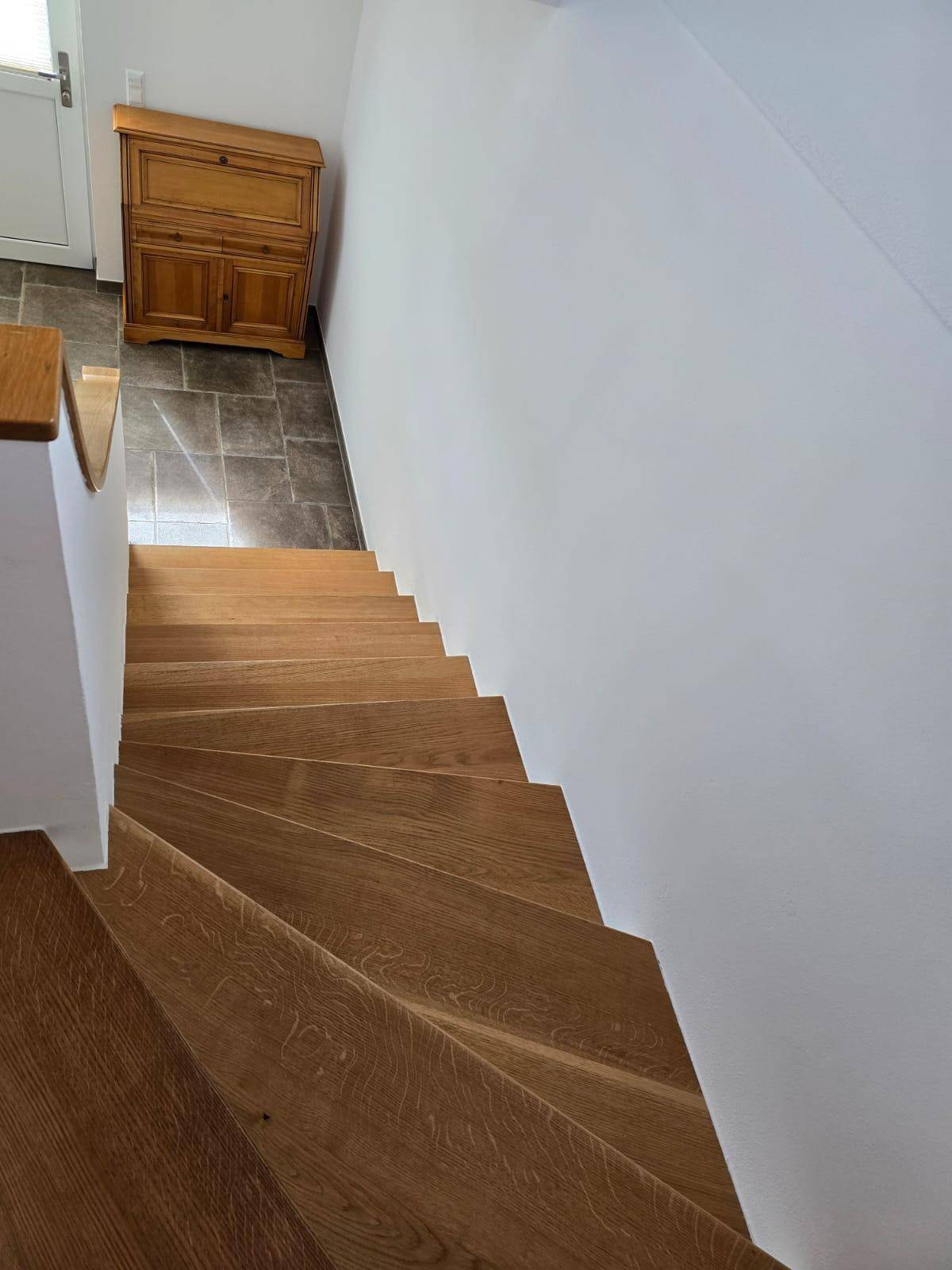 Holztreppe mit Eichenstufen, die verschiedene Ebenen des Hauses verbindet.