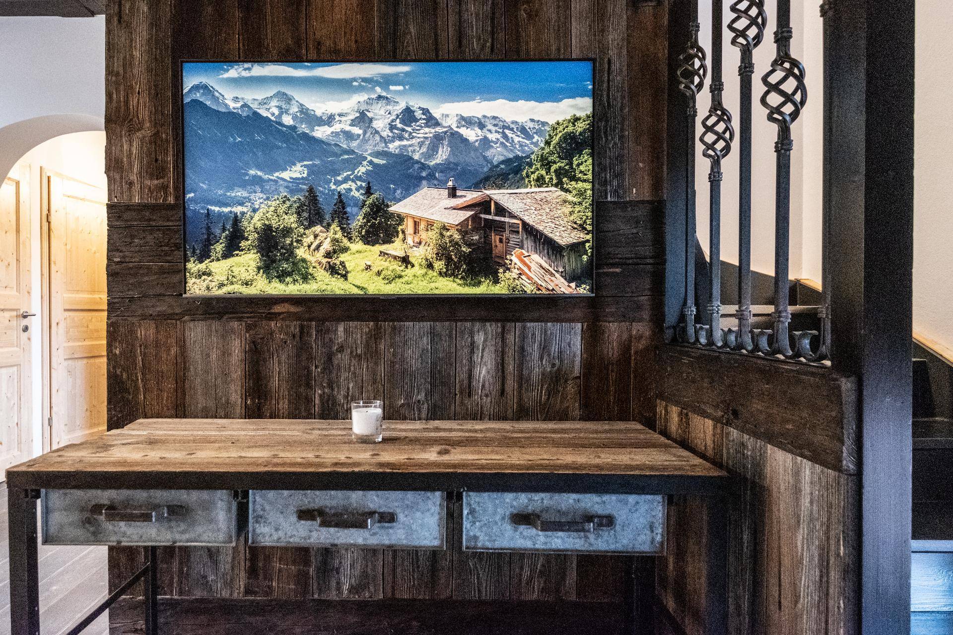Flurbereich mit Holzwänden, rustikalem Konsolentisch und großem Bergpanorama-Bild.