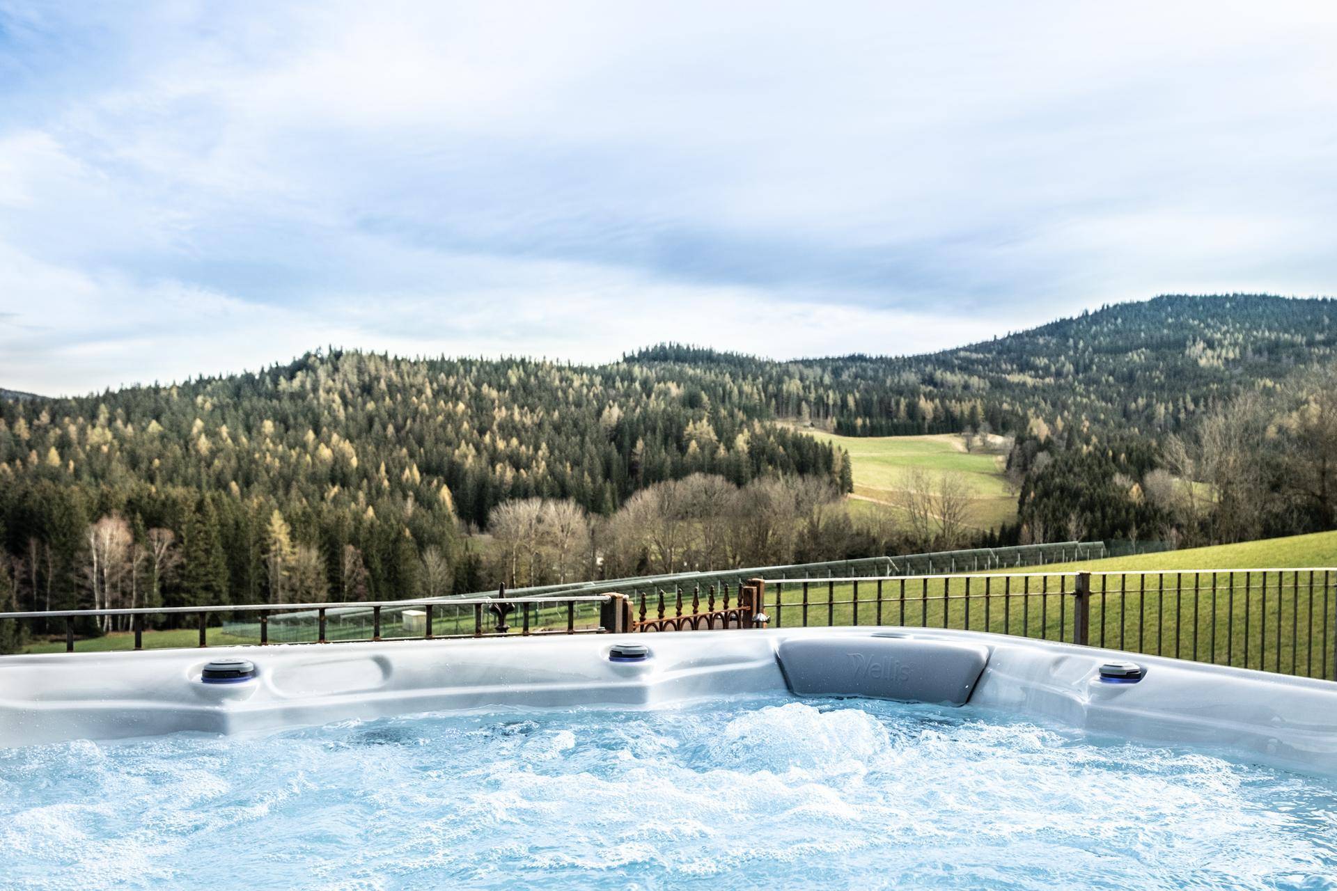 Whirlpool auf der Terrasse mit weitem Blick über die bewaldeten Hügel.