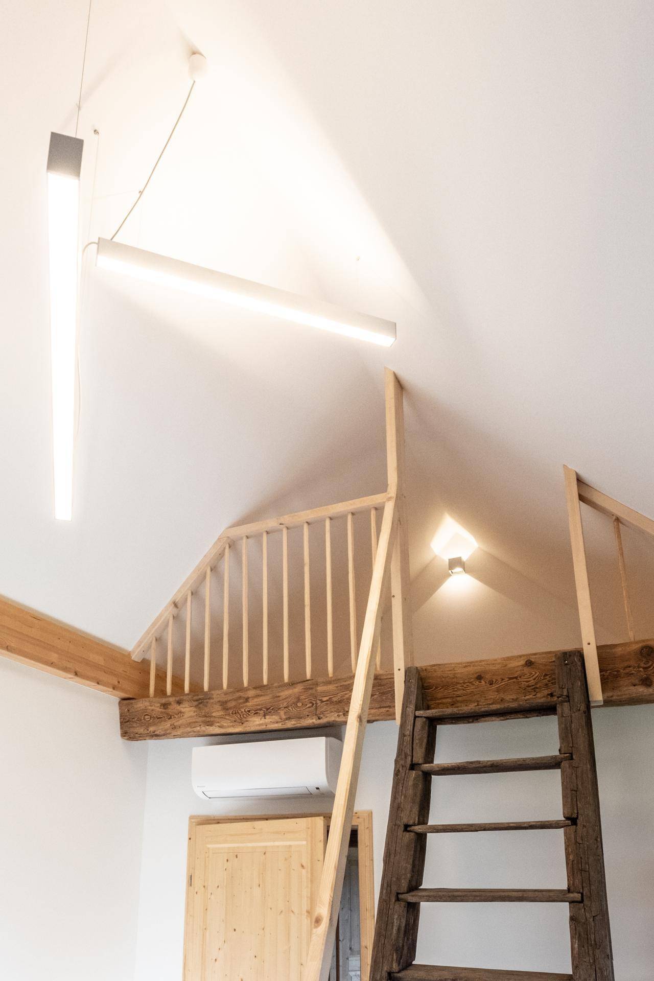 Hoher Raum mit Holzleiter zum Schlaf-Loft und Klimaanlage.