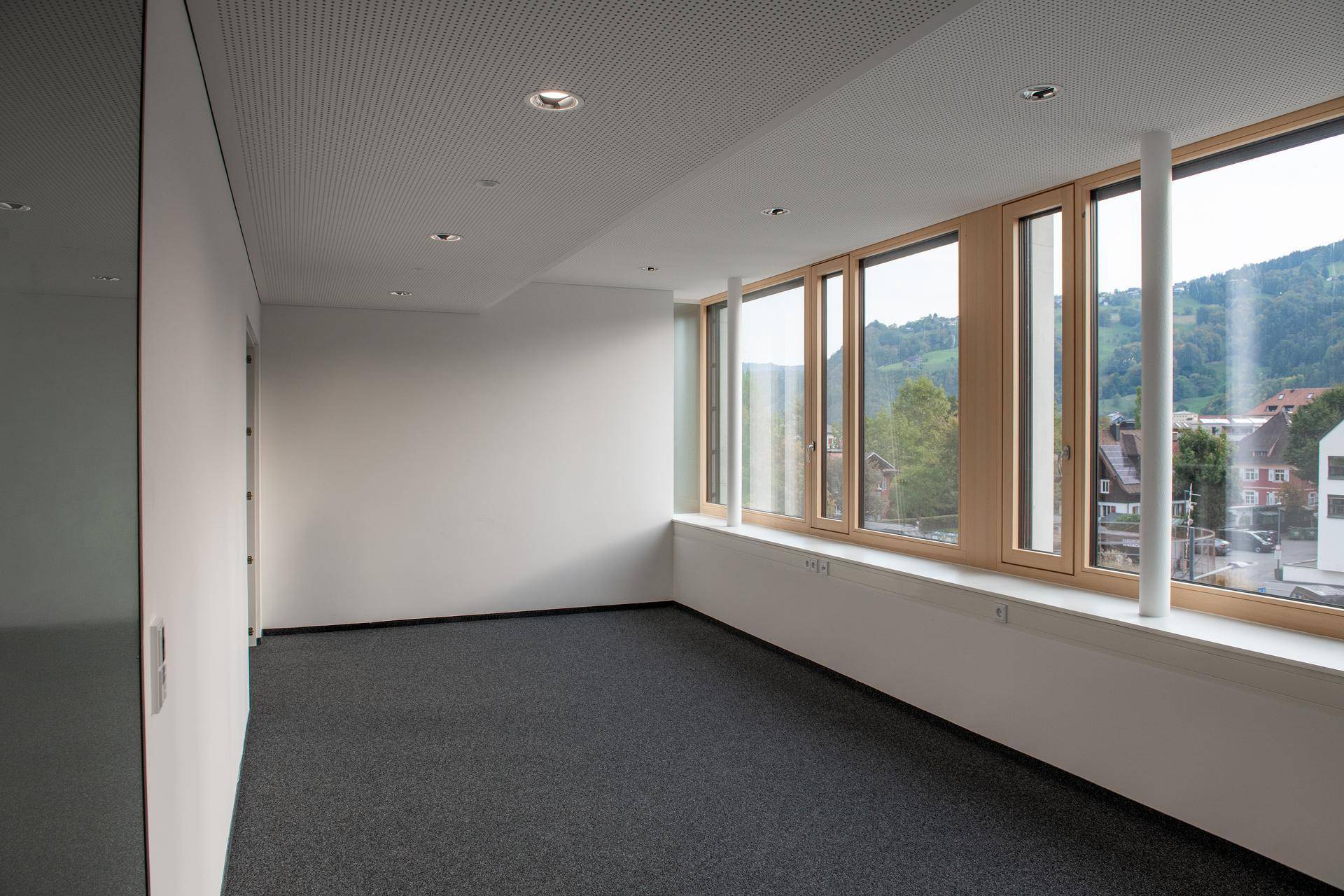 Geräumiger Büroraum mit großen Fenstern, die viel Tageslicht hereinlassen und eine helle Atmosphäre schaffen.