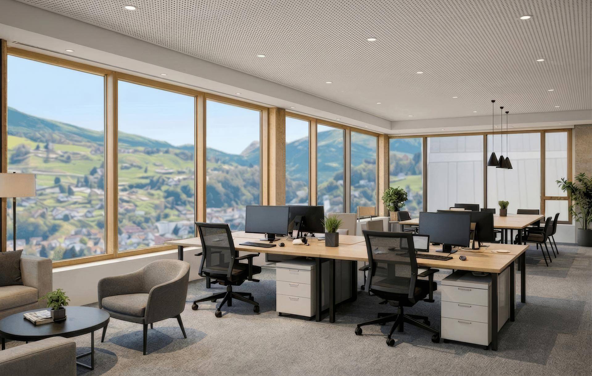 Helles, modernes Büro mit großen Fenstern und Panoramablick auf eine grüne Hügellandschaft.