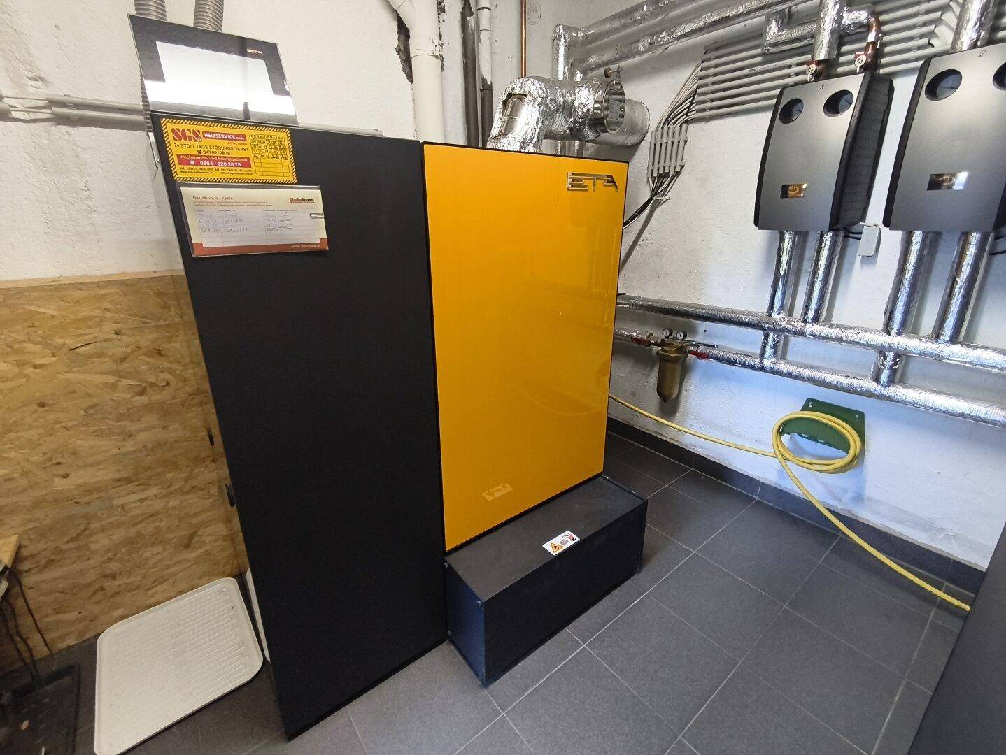 Technikraum mit einem modernen Heizsystem und sichtbaren Installationen.