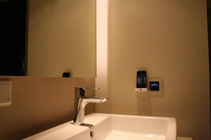 Detailansicht des modernen Waschbeckens mit Armatur und integriertem Smart-Home-Bedienfeld.