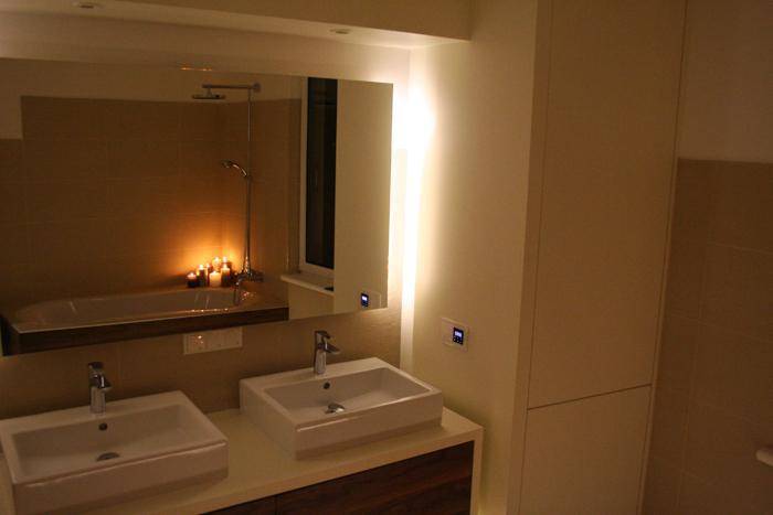 Modernes Badezimmer mit Doppelwaschbecken, großem Spiegel und integrierter Beleuchtung, stilvoll und funktional.