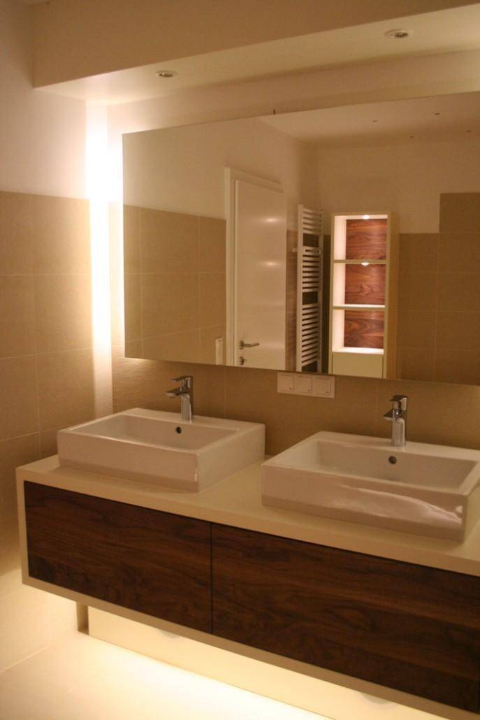 Elegantes Badezimmer mit Doppelwaschbecken, großem Spiegel und indirekter Beleuchtung für Komfort.