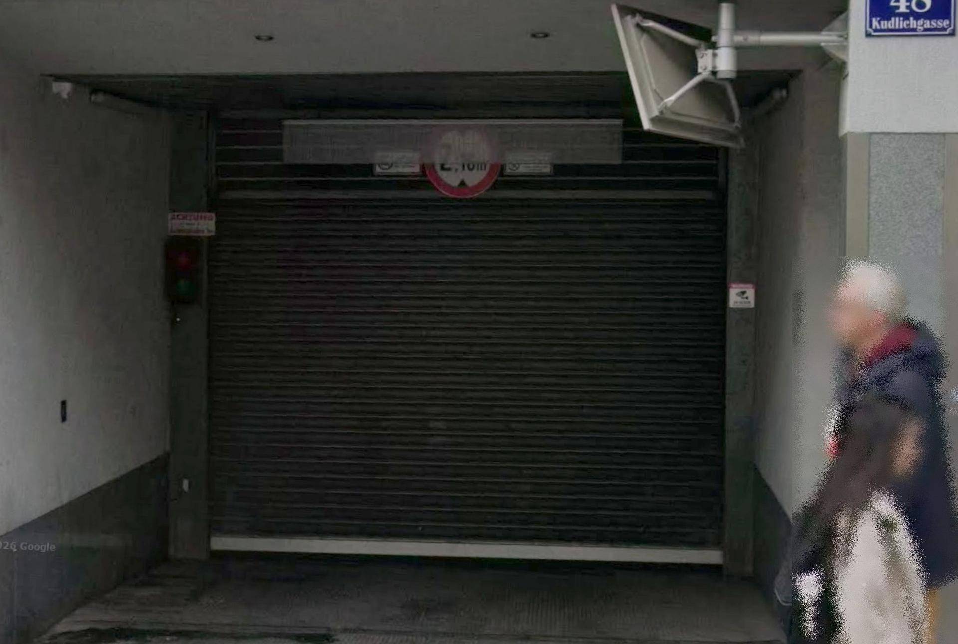 Eingang zu einer Tiefgarage mit geschlossenem Rolltor und Höhenbegrenzung an der Kudlichgasse.