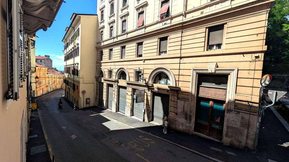 Historische Stadtstraße mit Geschäften, Gebäuden und einem sonnigen Himmel, der zum Flanieren einlädt.