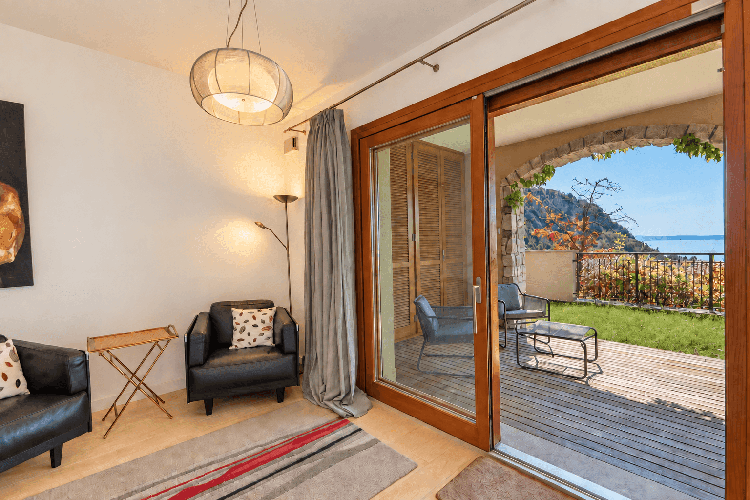 Gemütlicher Wohnbereich mit bequemen Sesseln, Holzboden und direktem Zugang zur Terrasse.