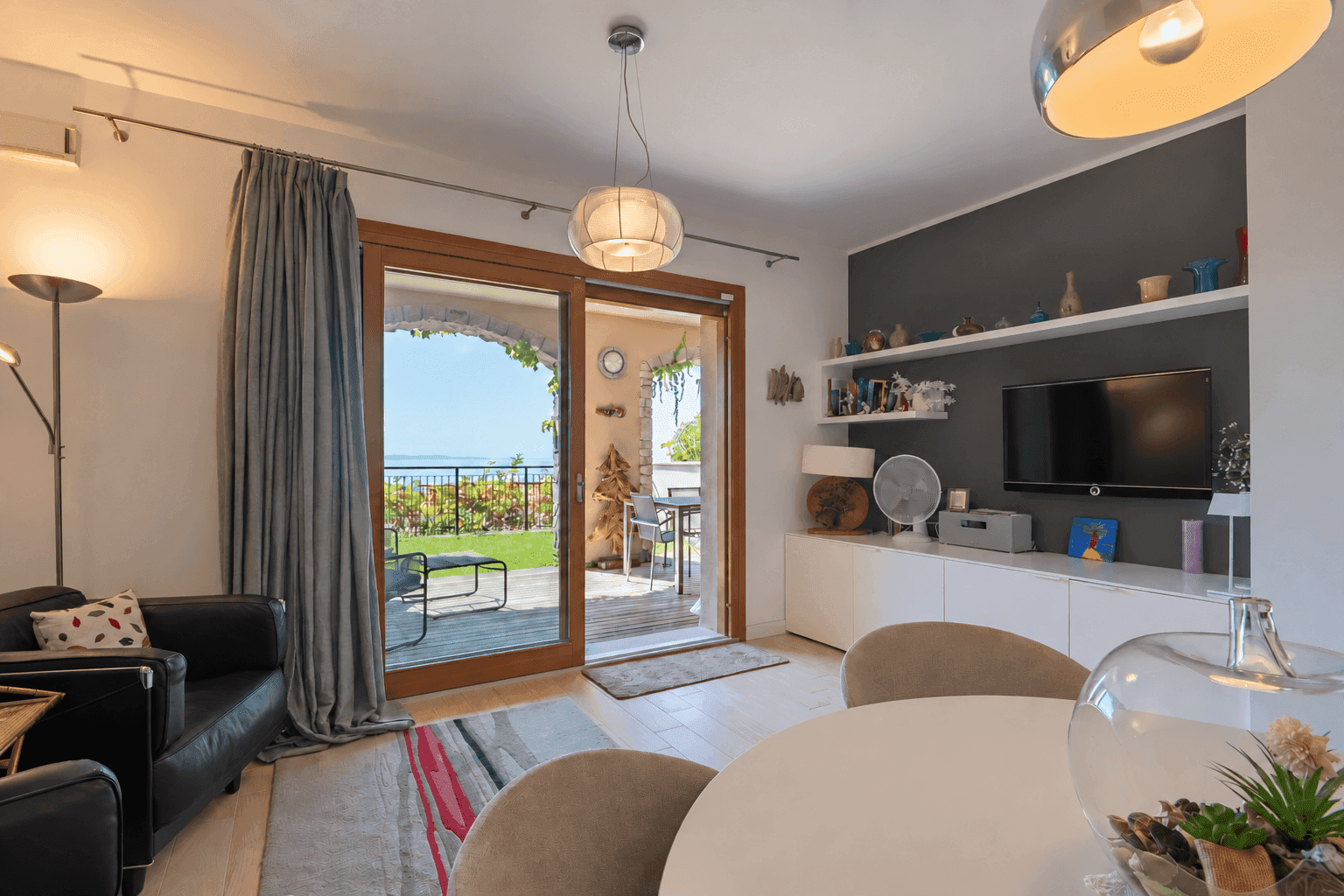 Heller Wohn- und Essbereich mit Zugang zur Terrasse und Blick auf das Meer.