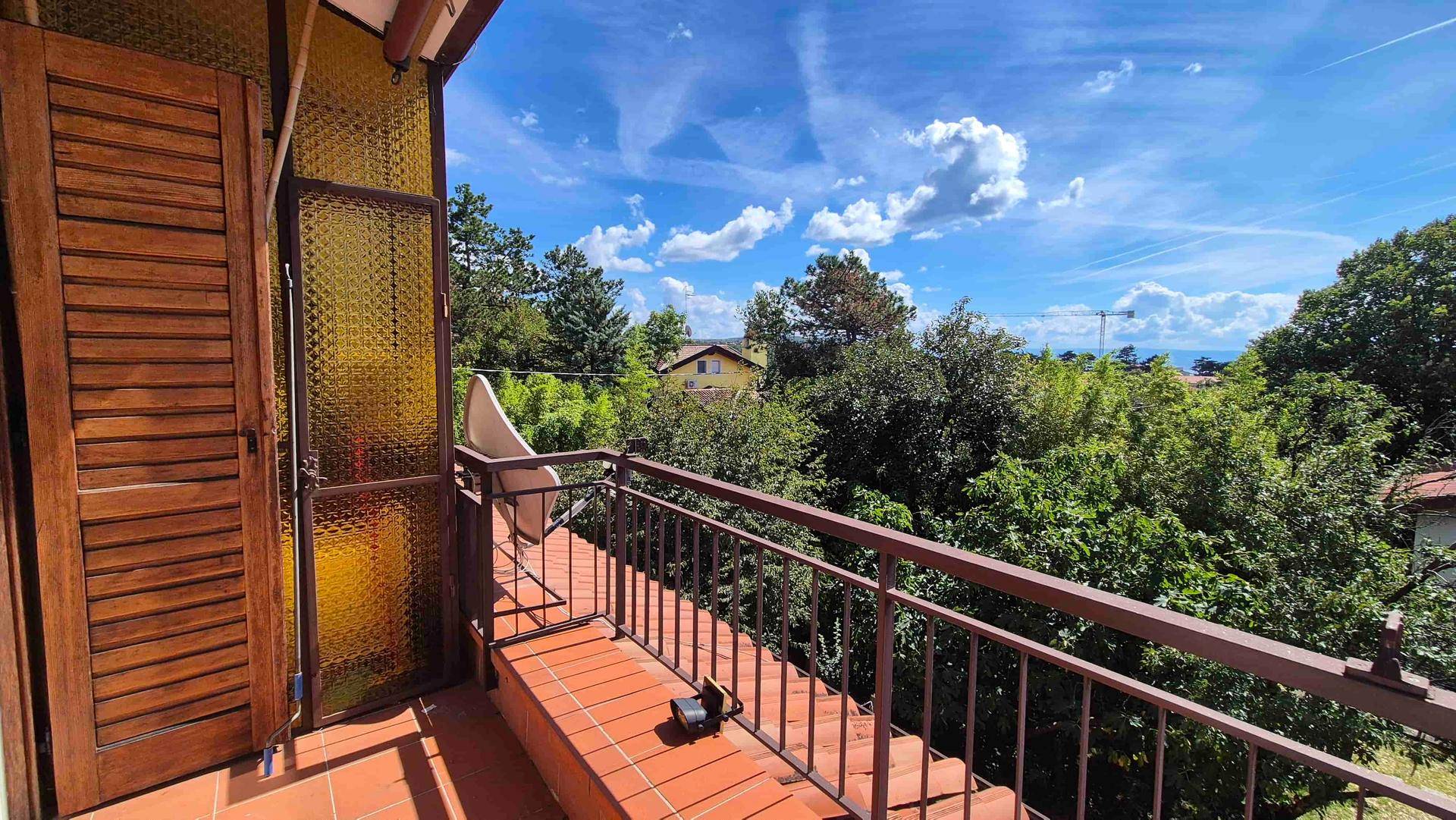 Geräumiger Balkon mit Terrakottaboden und weitem Blick über die grüne Landschaft.