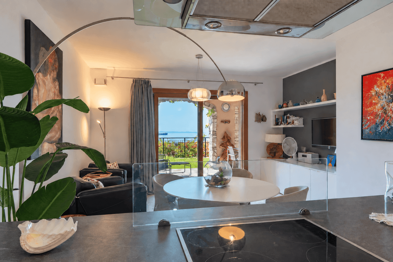 Offene Küche mit Blick auf den Wohn-Essbereich und die Terrasse mit Meerblick.