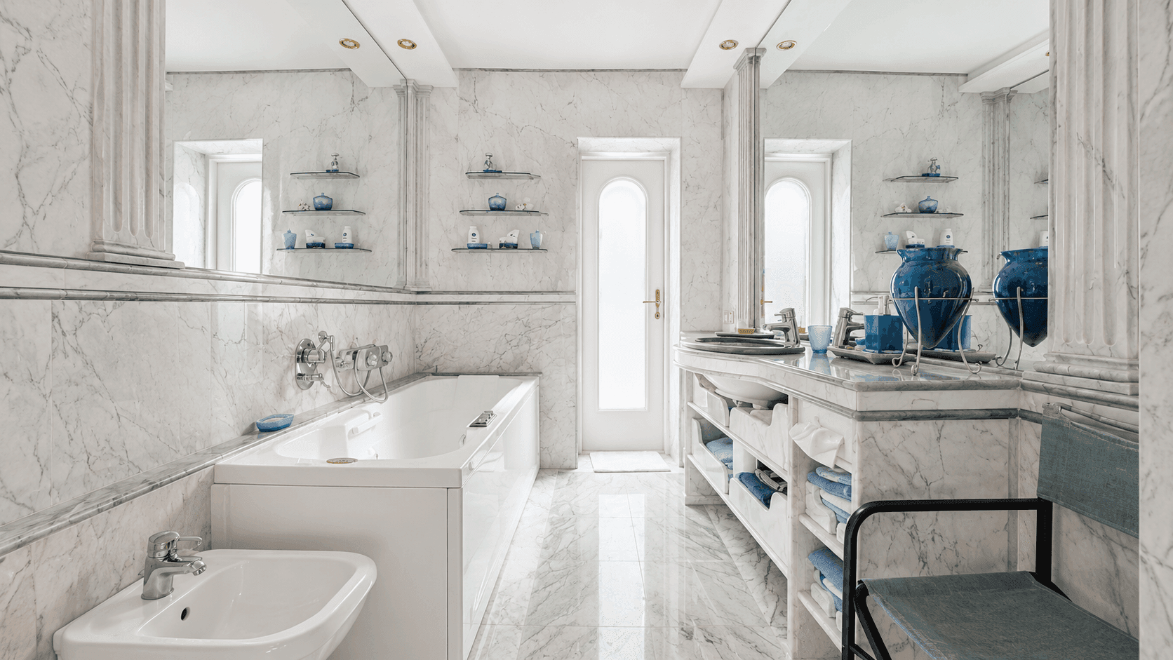 Luxuriöses Badezimmer mit Marmorfliesen, Badewanne, Bidet und Doppelwaschbecken.
