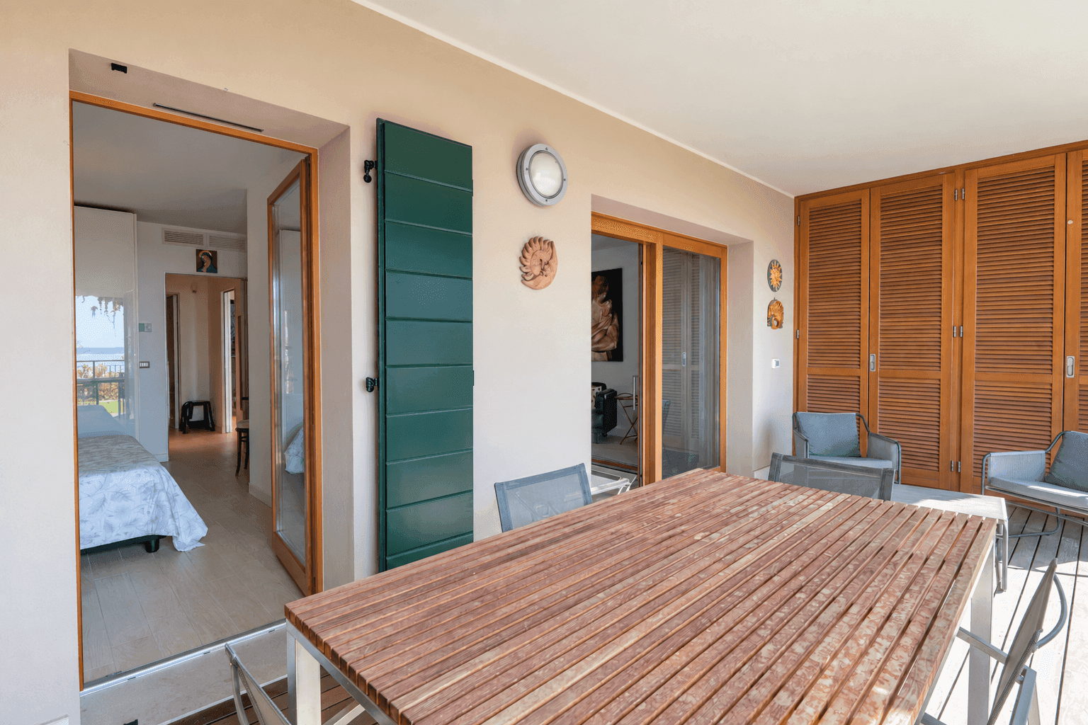 Geräumige Terrasse mit Esstisch und Zugang zu den Innenräumen des Apartments.