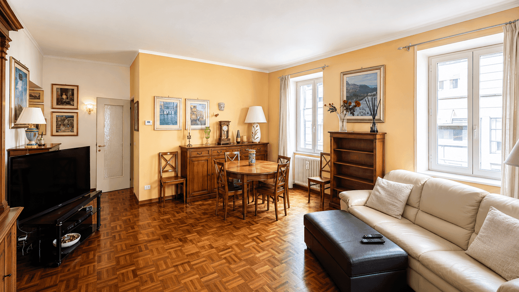 Geräumiger offener Wohn- und Essbereich mit Parkettboden, Esstisch und bequemen Sofas, ideal für geselliges Beisammensein.