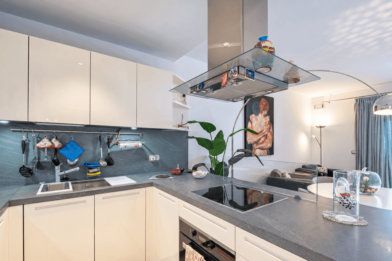 Moderne Einbauküche mit hellen Schränken, dunkler Arbeitsplatte und Induktionskochfeld.