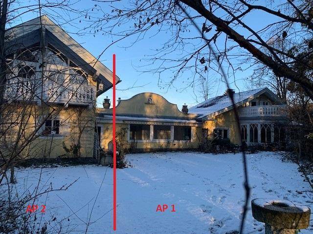 Historisches Gebäude mit gelber Fassade und Balkonen, umgeben von einer winterlichen Schneelandschaft.