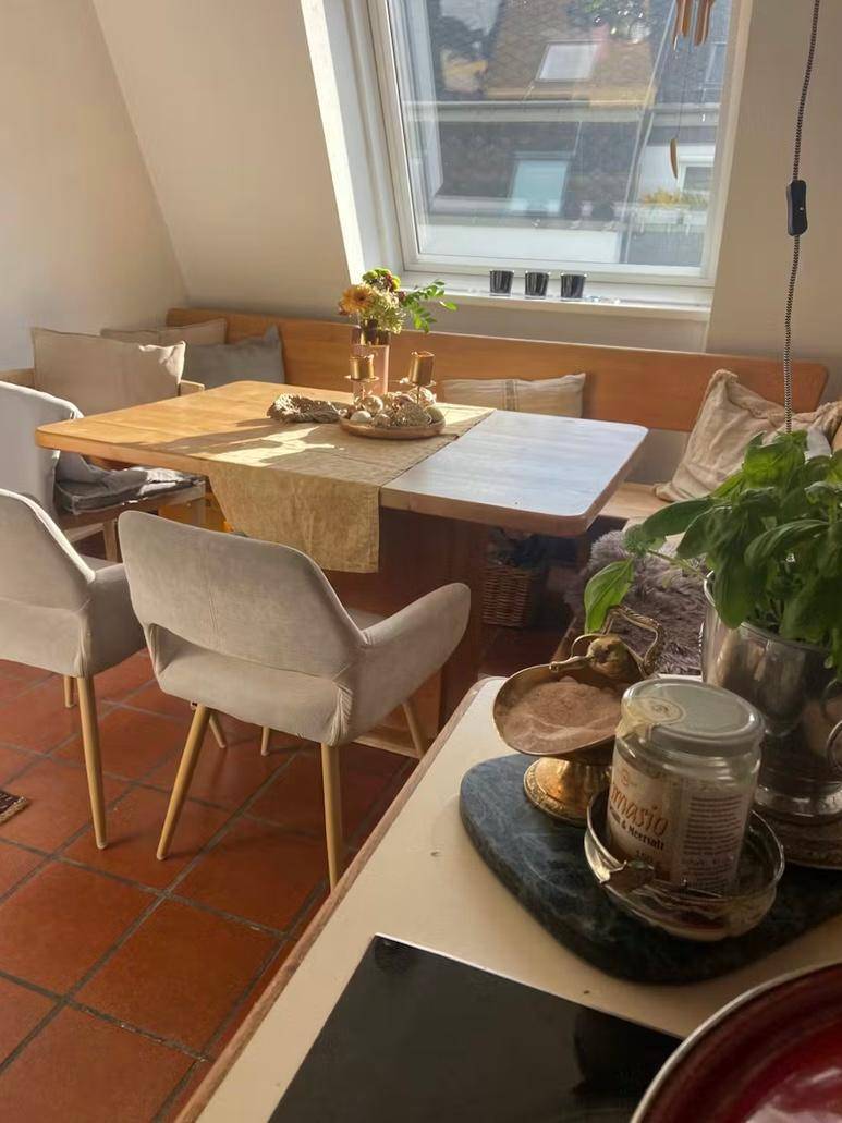 Gemütlicher Essbereich mit Holztisch, Sitzbank und Dachfenster, ideal für Mahlzeiten.