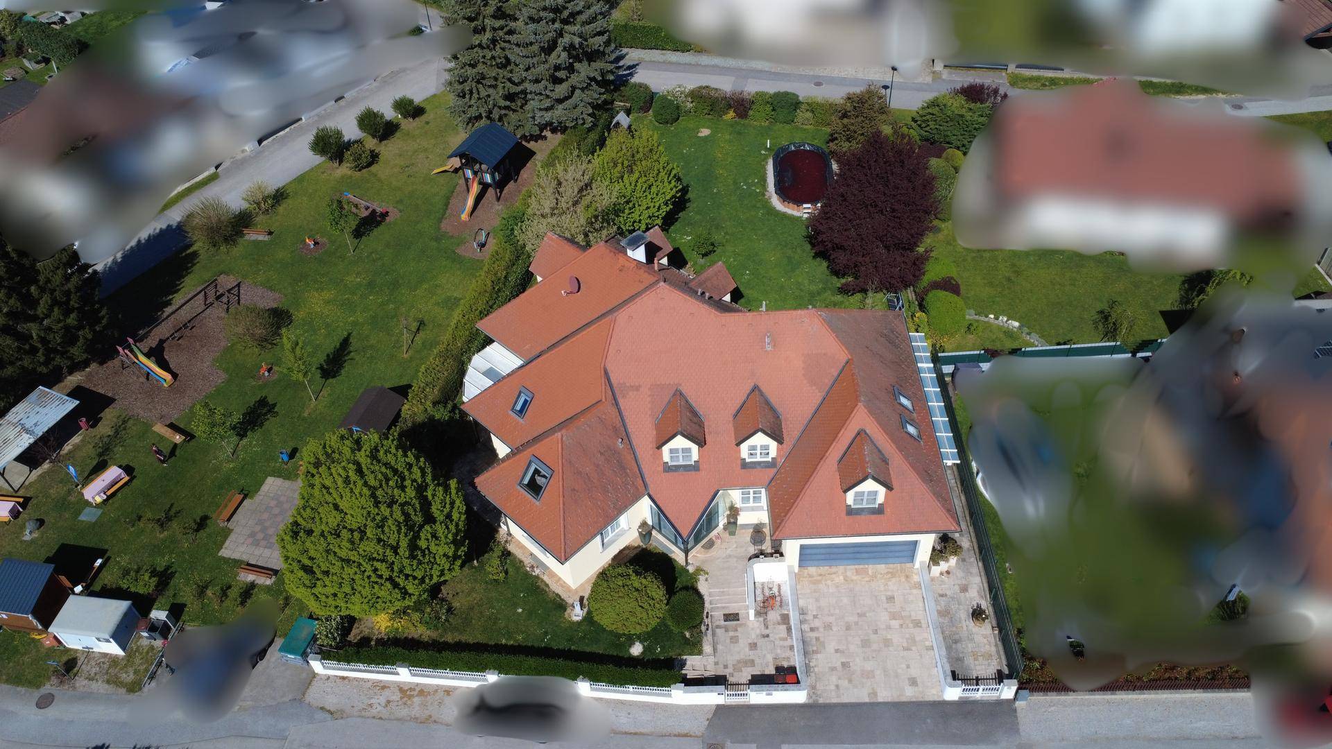 Luftaufnahme des Anwesens mit großem Garten, Pool und Spielplatz.