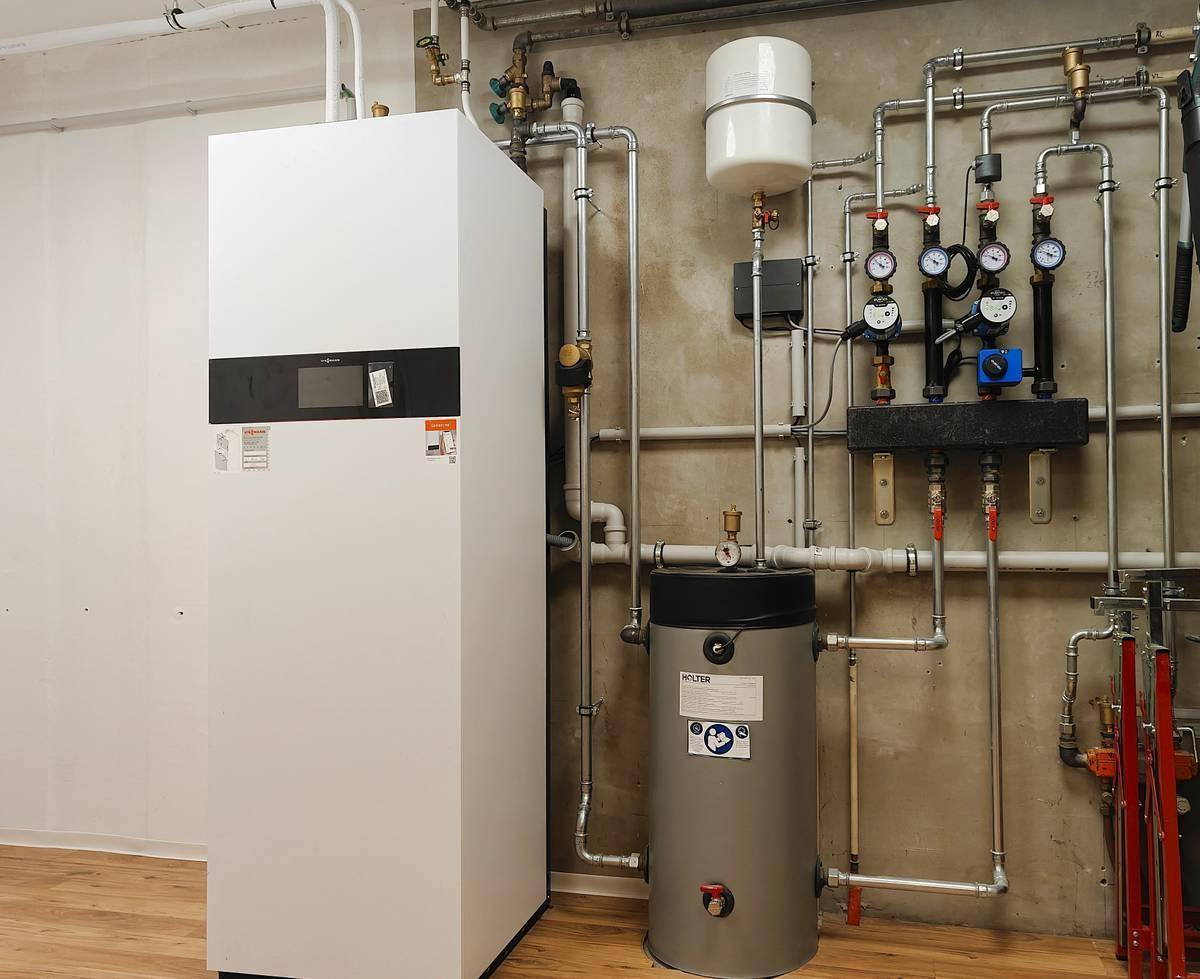 Heizungsanlage und Warmwasserspeicher in einem Technikraum.