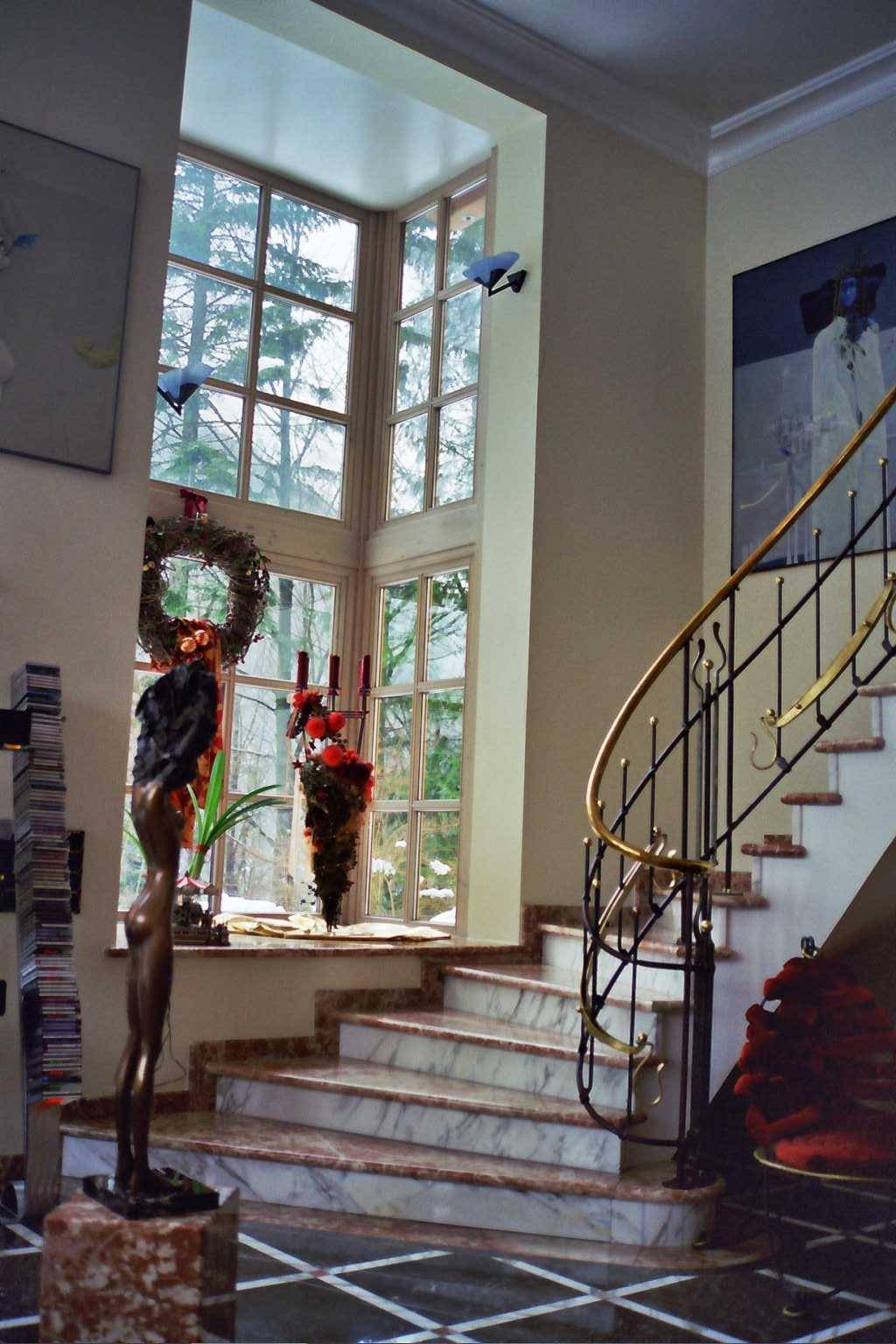 Elegante Marmortreppe mit großem Eckfenster, das viel natürliches Licht hereinlässt.