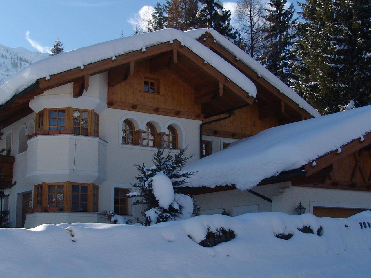 Charmantes Haus im Schnee mit Holzelementen und alpiner Architektur.