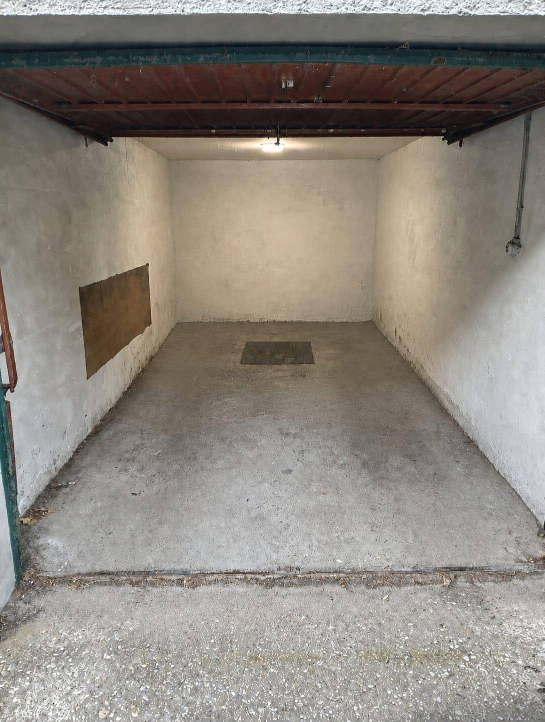 Leere Garage mit Betonboden und einfachen Wänden, bereit zur Nutzung als Stellplatz.