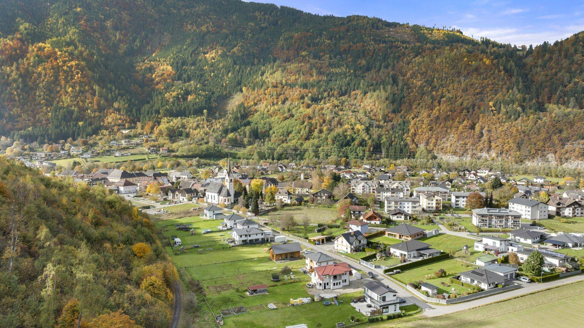 Malerische Berglandschaft mit einem Dorf und vielen Häusern im Herbst.