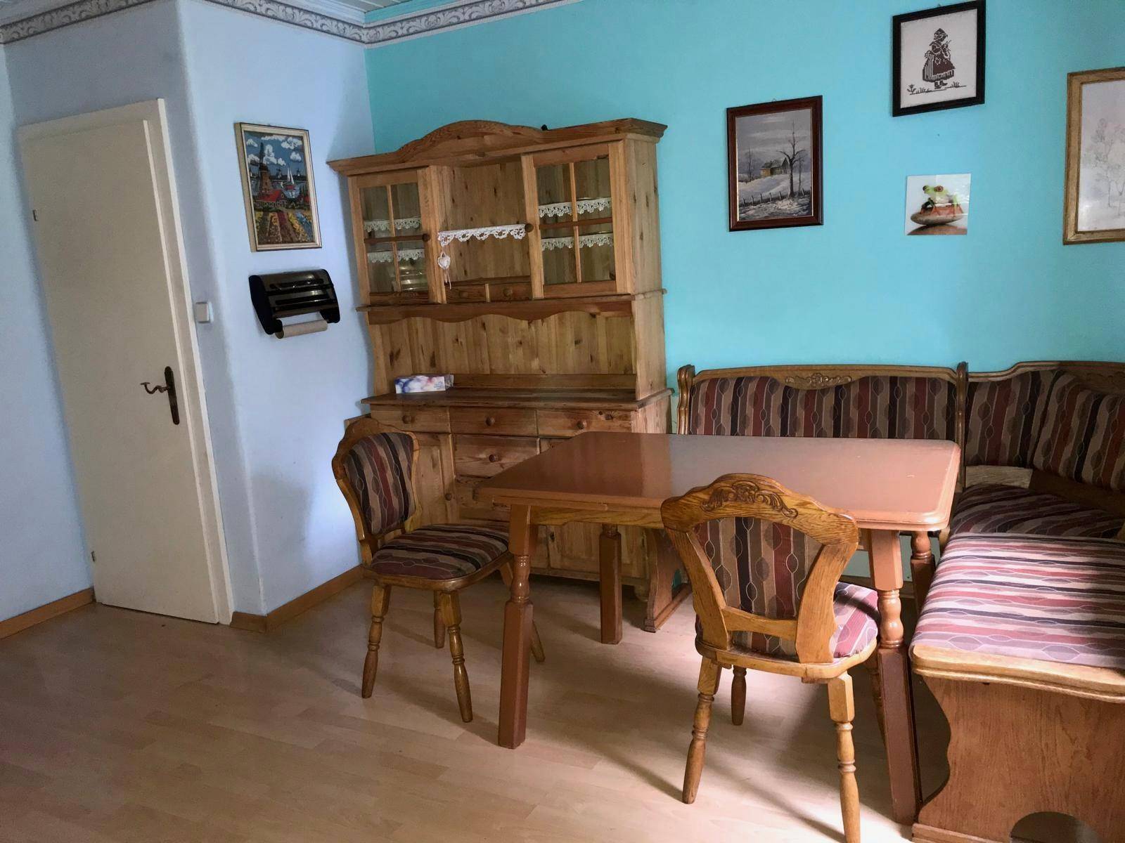 Gemütlicher Essbereich mit traditionellen Holzmöbeln, Eckbank und hellblauen Wänden.