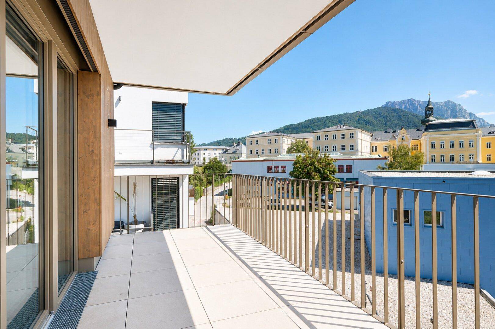 Geräumiger Balkon mit Fliesenboden und weitem Blick über die Stadt und die umliegenden Berge.