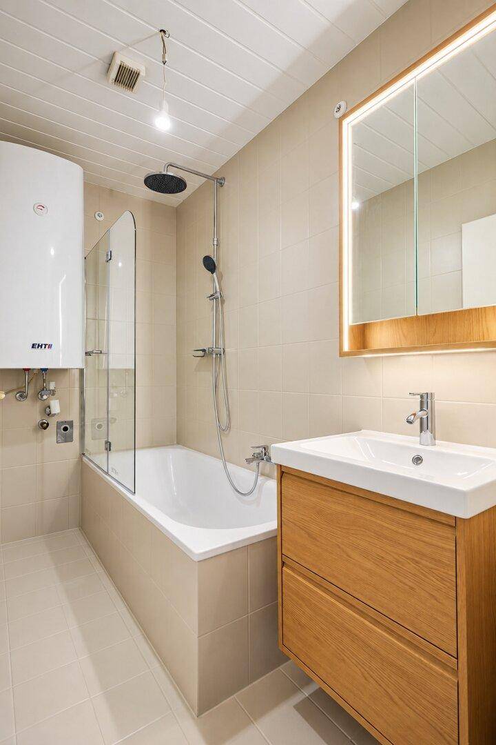 Modernes Badezimmer mit Badewanne, Dusche und Holzwaschtisch, in hellen Beigetönen gehalten.