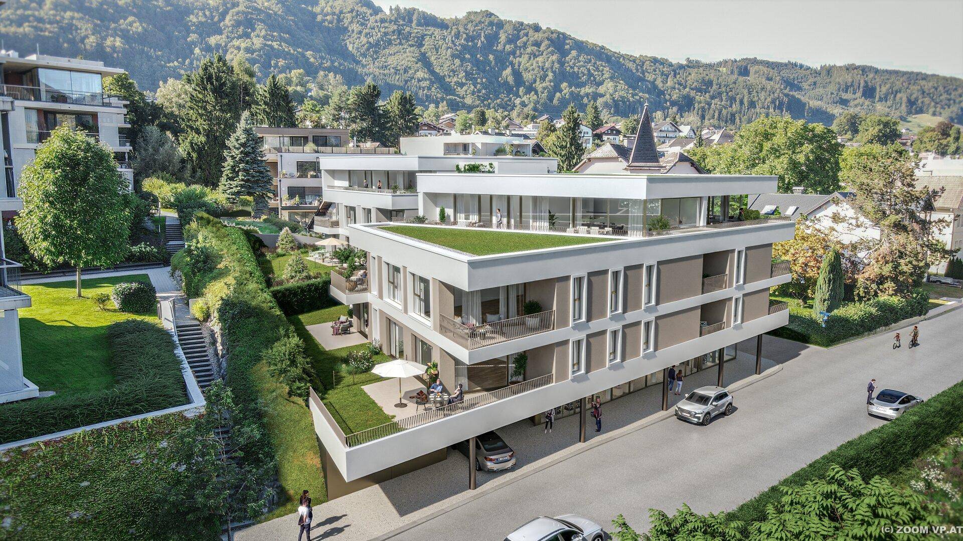 Gesamtansicht der modernen Wohnanlage mit Tiefgaragenzufahrt und gepflegten Außenbereichen.